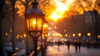 Vintage street lamp glowing at sunset with blurred people walking in park, golden bokeh lights creating romantic atmospheric evening scene.