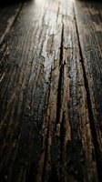 Weathered wooden planks with deep grain texture and natural aging, showing cracks and worn surface details for rustic design projects.