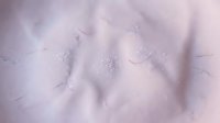 Soft white powder texture with fine granules and subtle shadows, suitable for cosmetics, skincare, and beauty product backgrounds.