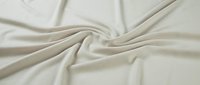 Smooth beige fabric with soft folds and drapes, showcasing natural textile texture and material quality for design and fashion projects.