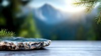 Stone on wooden table with majestic mountain view in background, pine branches framing serene outdoor scene with soft focus natural landscape.