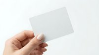 Hand holding blank white business card mockup on light background for branding and corporate identity design projects.