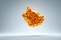 Raw amber stone floating against minimalist gray background, showcasing natural honey-colored fossil resin for jewelry making or collection.