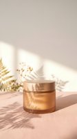 Luxury golden cosmetic jar with cream on neutral background with natural plant shadows and warm sunlight for skincare and beauty product mockup.