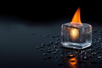 Burning flame inside ice cube with water drops on dark background creates dramatic contrast between fire and ice, showcasing natural elements duality.