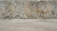 Weathered concrete wall texture with porous surface and natural aging patterns for industrial design backgrounds and architectural projects.