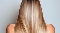 Young woman with long straight blonde balayage hair shown from behind, demonstrating professional hair coloring technique and healthy, shiny hair texture.