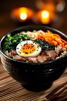 Korean bibimbap bowl with soft boiled egg, marinated pork, carrots, spinach and nori served in traditional stone bowl. Atmospheric restaurant lighting creates cozy mood.