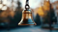 Antique bronze bell hanging on chain against blurred autumn background with bokeh lights and golden foliage, symbolic of time, tradition and celebration.