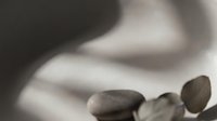 Close-up of smooth stones held in open palm, conveying wellness, meditation, and spa therapy concepts for relaxation and mindfulness applications.