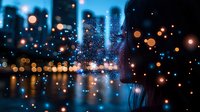 Blurred city skyline at night with glowing bokeh lights and water reflections creating dreamy urban atmosphere. Artistic photography for mood and ambiance.