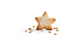 Star shaped sugar cookie dusted with powdered sugar on white background with scattered cookie crumbs, minimalist holiday baking composition.