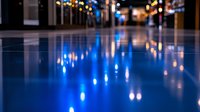 Blurred city street at night with colorful bokeh lights reflecting on wet pavement creating abstract urban atmosphere for backgrounds and design projects.