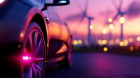 Luxury car wheel and side panel detail at sunset with blurred city lights creating atmospheric bokeh background, dramatic urban automotive scene.