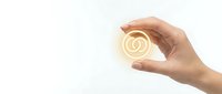 Hand holding glowing golden copyright symbol with light rays on white background for intellectual property and legal protection concepts.