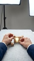 Businessman hands assembling wooden puzzle pieces with glowing light bulb revealing creative solution and innovation in professional setting.