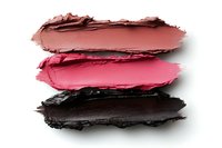 Smeared cosmetic texture samples showing brown, pink and dark purple cream makeup swatches on white background, isolated for beauty and fashion design projects.