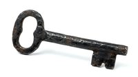 Antique iron skeleton key with ornate oval handle and weathered patina, isolated on white background, suitable for vintage design, historical graphics, and decorative projects.