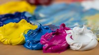 Vibrant acrylic paint colors mixed on artist palette with brush strokes. Creative art supplies for painting projects and artistic expression.