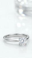 Classic solitaire diamond engagement ring with brilliant cut stone on white gold band against soft bokeh background for wedding proposals.