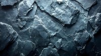Dramatic dark slate rock formation with jagged edges and natural texture creates moody background for design projects. Natural light highlights rough surface details.