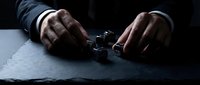 Businessman hands in handcuffs on dark surface representing corporate crime, legal troubles, arrest, corruption, fraud investigation, business ethics violation.