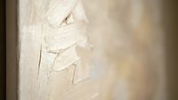Wood shavings and curls from carpentry work on light wooden surface with natural grain texture and warm lighting creating artisan craftsmanship atmosphere.