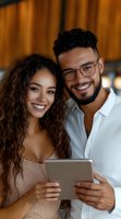 Young diverse couple smiling while looking at digital tablet together. Mixed race millennials using mobile device for online shopping or entertainment.