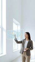 Woman in business casual attire interacting with holographic communication icons including phone, email, and chat symbols in bright modern office space with natural light.