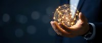 Businessman holding a glowing digital globe with network connections, symbolizing global communication, technology, and innovation in business.
