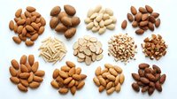 Assorted nuts including almonds, cashews, peanuts, and hazelnuts arranged on white background for food and nutrition design projects.