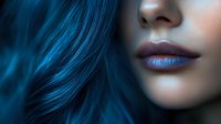 Close up of lips with metallic blue lipstick and vibrant blue hair against dark background, creating mysterious and ethereal beauty look for cosmetic and fashion concepts.