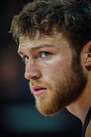 Young athletic Caucasian man with curly hair and beard sweating after intense workout or sports training session showing determination and focus.