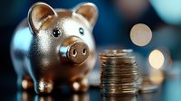 Copper piggy bank with stack of coins on blurred background with bokeh lights for savings and financial planning concepts.