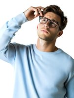Young Caucasian man in light blue sweater wearing glasses scratching head with confused expression isolated on white background for business concepts.
