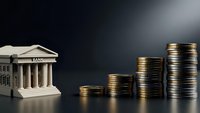 Bank building with classical columns next to ascending stacks of golden coins representing financial growth, savings, investment and monetary success concepts.