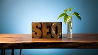 Wooden SEO letters on desk with green plant symbolizing organic search engine optimization growth and digital marketing success for business websites.