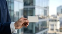 Man in business suit holding blank white card with urban cityscape background, suitable for corporate branding, networking, and professional business concepts.