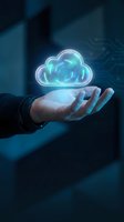 Businessman hand holding glowing cloud computing hologram in dark blue office environment representing digital transformation and data storage solutions.