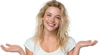 Young blonde woman with tousled hair smiling broadly with open palms gesture against white background, conveying happiness and welcoming attitude.