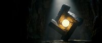 Underground tunnel with bright light source illuminating dark stone walls creating dramatic atmospheric lighting for mining or cave exploration concepts.