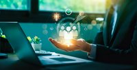 Businessman hand holding glowing human resources icons with laptop in modern office environment for HR management and team building concepts.