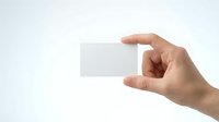 Hand holding blank white business card mockup on light background for branding and corporate identity design projects.
