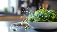 Fresh green salad leaves in white bowl with magical sparkles and light effects, healthy eating concept on dark background with selective focus.