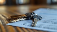 Car keys resting on legal documents or contract papers with shallow depth of field, suggesting real estate, vehicle purchase, or rental agreement concepts.
