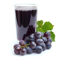 Fresh grape juice in glass with ripe purple grapes and green leaf isolated on white background, natural organic beverage for healthy lifestyle.
