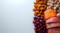 Fresh raw salmon and tuna slices with almonds, frozen cranberries and ginger root arranged on light gray background, omega-3 rich healthy food ingredients.