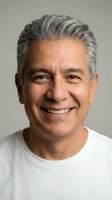 Mature Hispanic man with gray hair smiling warmly in white shirt against neutral background for lifestyle and wellness content.