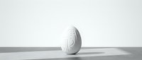 White decorative Easter egg with geometric pattern standing on clean surface against neutral background for spring holiday designs.