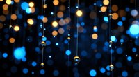 Magical glowing blue and gold bokeh lights with hanging crystal drops creating dreamy festive atmosphere against dark background. For holiday designs.